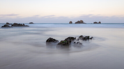 Fototapeta na wymiar olas rodeando roca en la playa