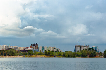 High city buildings are located behind the strip on the background of the city Park with a beach...