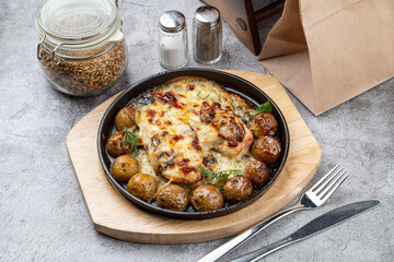 Unpeeled baby potatoes with chicken breasts coated in creamy gravy baked and served in cast iron skillet