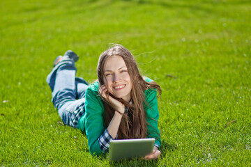Naklejka na ściany i meble Young woman working on laptop while resting in a city park