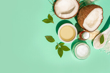 Obraz na płótnie Canvas Natural coconut cosmetics on a blue background. Oil, cream and coconuts