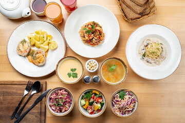 A whole cafe menu on a wooden table, directly above view with artificial light