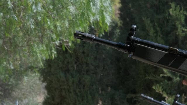 Close-up side view of the barrel of several rifles shooting at the same time.