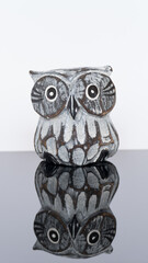 wooden figurine of an owl isolated on a mirror board
