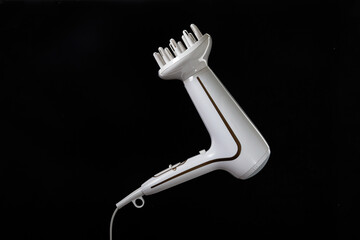 Professional stylish hairdryer isolated over a black background. White Ionic Hair Dryer with Hair Care Tool. Modern Blow Dryer.