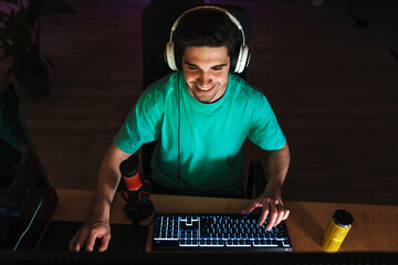 Image of caucasian happy man playing video game on computer