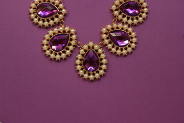 luxury purple jewelry in the Baroque style on a purple background. Vintage, retro style.
copy space
