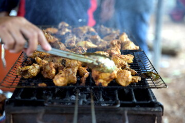 Street food Vendor preparing Barbecue Chicken at Street Food Bazaar
