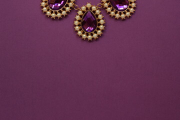 luxury purple jewelry in the Baroque style on a purple background. Vintage, retro style.
copy space
