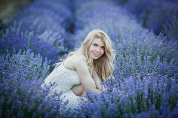 women on lavander field in white dress, blond long hair.