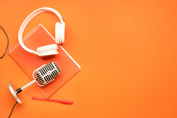 Headphones with microphone and notebook on color background - obrazy, fototapety, plakaty