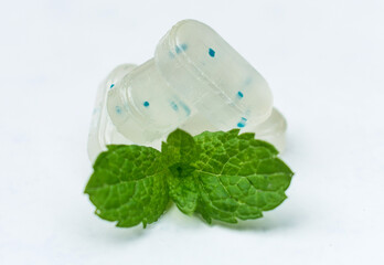 Fototapeta na wymiar Mint breath freshening candies and mint leaves on a white background. Close-up.