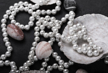 Jewelry made of natural pearls on a black background, shells and sea stones. Close up.