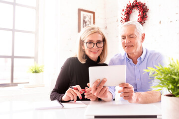Happy senior couple using a touchpad while making video call