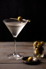 Martini with olives. On a wooden background