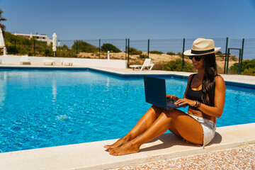 Digital nomad working with the laptop in the swimming pool. Lifestyle working remote