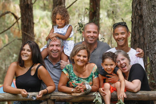Bellissima famiglia Multientinica Italo - Brasiliana si raduna vicina in un  contesto naturale di una pineta 
