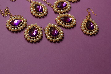 luxury purple  jewelry in the Baroque style on a purple background. Vintage, retro style.
copy space
