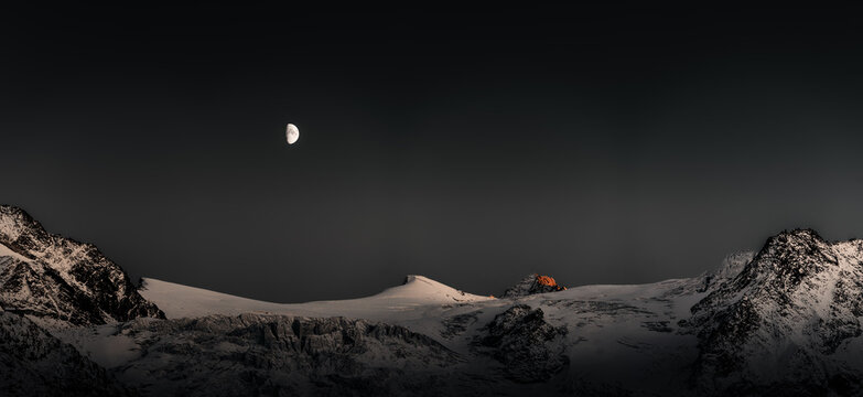 Der Mond schein über am nächtlichen Himmel über dem Gipfel des Col de Rosses in den schweizer Alpen 