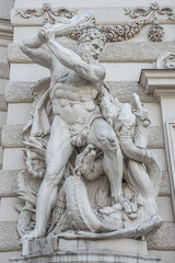 Fototapeta na wymiar Statue of fight of Hercules with a club and Hydra, serpent like water monster from Classical Greek Mythology, Hofburg Palace, outdoor, Vienna, Austria, details, closeup