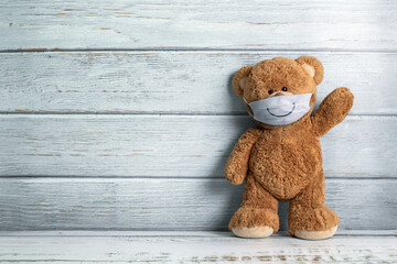 Cute teddy bear smiling behind the mask have a happy face for social distancing concept. with copy space.
