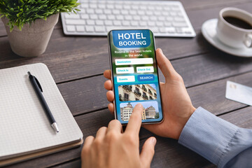 Naklejka na ściany i meble Smartphone with open hotel booking application in male hands