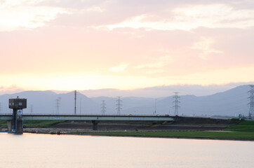 淡い夕焼けと鉄塔と川