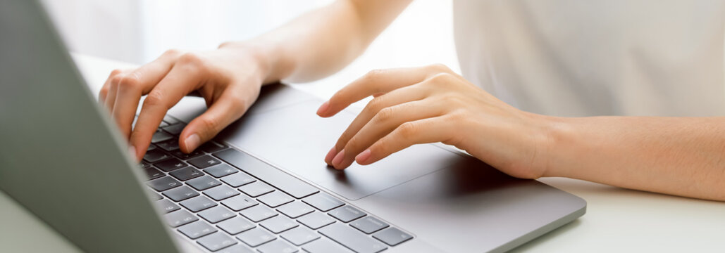 Hand using laptop computer with the press keyboard at office. proportion of the banner for ads.