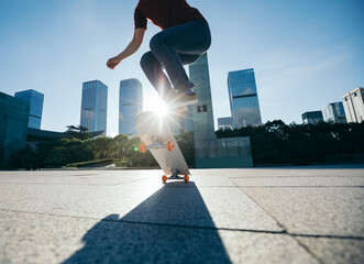 Fototapeta na wymiar Asian woman skateboarder skateboarding in modern city