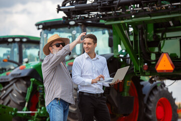 Professional farmer with a modern combine at field in sunlight at work. Confident, bright summer...