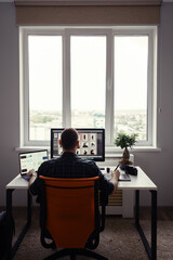 Freelancer man working remotely from home. Young male working on his computer