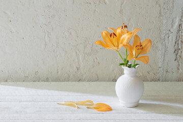 lilies in white vase on white background