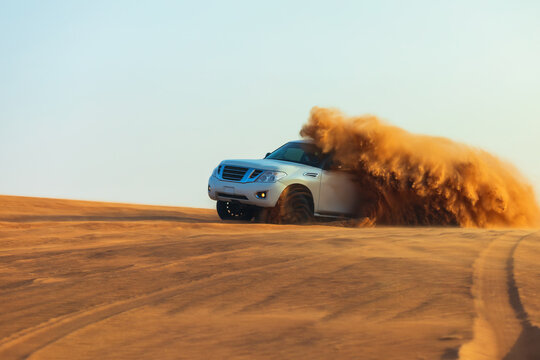 Offroad drifting adventure with 4x4 car dune bashing through sand dunes in desert.