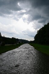 Heavy, dark clouds over picturesque Grajcarek stream in Szczawnica, southern Poland. Summer in Pieniny Mountains. Before storm