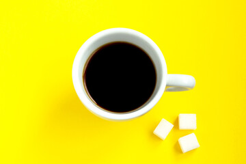 Black coffee with pieces of sugar in a white cup