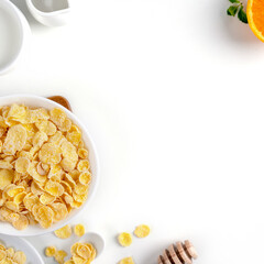 Corn flakes bowl sweeties with milk and orange on white background, top view, flat lay overhead layout, fresh and healthy breakfast design concept.