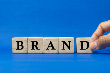 hand hold woodblock to complete the word brand, as brand management concept