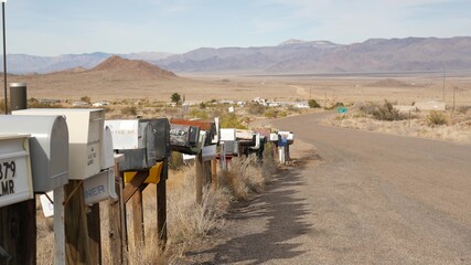 Row of vintage drop boxes on road intersection, arid Arisona desert, USA. Postal retro mailboxes on roadside of tourist Route 66. Address on old-fashioned nostalgic metal grunge postbox on pillar