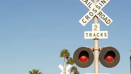 Level crossing warning signal in USA. Crossbuck notice and red traffic light on rail road...