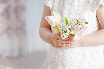 Sweet little girl holding  flowers in hands. Close up photo. Copy space