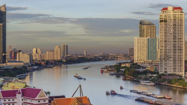 Footage 4k Timelapse, Overhead view of the business area Bangkok skyline near Sathorn Bridge beside of Chao Phraya River that has a lot of boat running on a river.