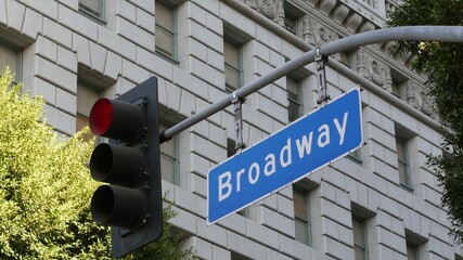 Broadway street name, odonym sign and traffic light on pillar in USA. Road intersection in downtown...