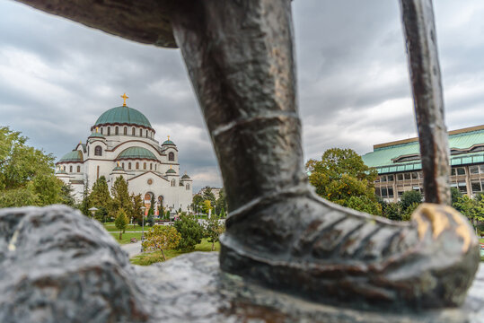 BELGRADE, SERBIA - July 10 2019 Beautiful Saint Sava christian catedral in the background with left foot in foreground of famous Karadjordje monument in Belgrade Serbia