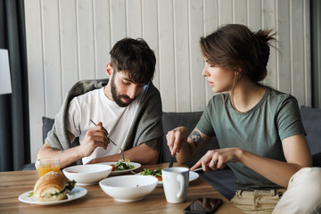 Lovely young couple having healthy breakfast in the kitchen