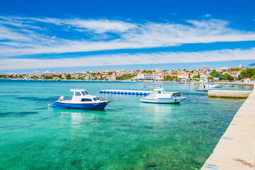 Fototapeta na wymiar Croatia, town of Novalja on the island of Pag, boats in marina and turquoise sea with boats in foreground