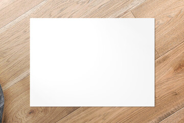 Top view of blank Horizontal A5 Poster on wooden background