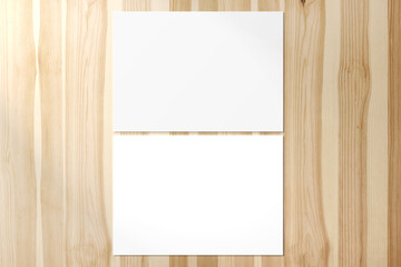Two blank horizontal A5 Poster on shiny wooden desk
