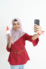 beautiful asian woman video calling using smartphone during independence day of indonesia