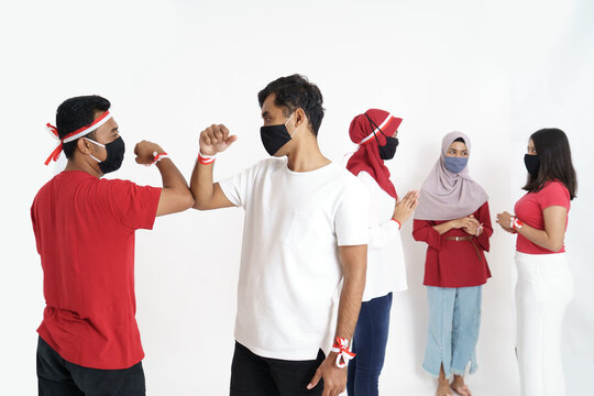 indonesian people elbow shake hand during independence day due to corona virus outbreak - Powered by Adobe