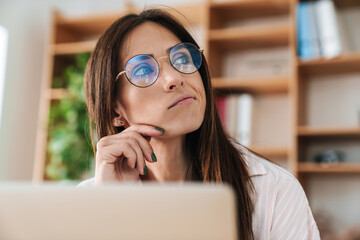 Image closeup of brooding adult businesswoman working with laptop